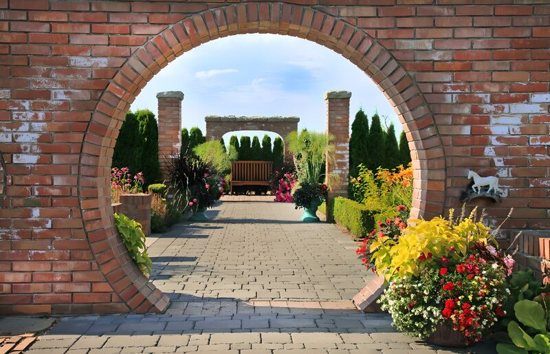 Gartenweg durch einen Ziegelbogen