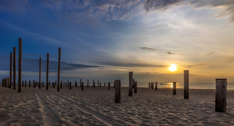 Pfahlreihen am Strand bei Sonnenuntergang
