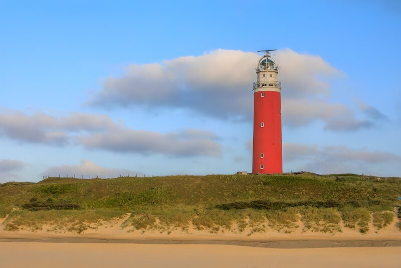 Leuchtturm am Strand bei klarem Himmel