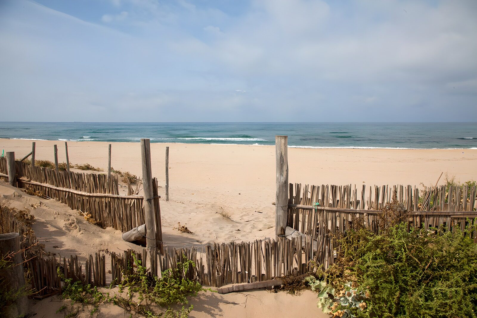 Ruhiger Strand mit Holzsichtschutz