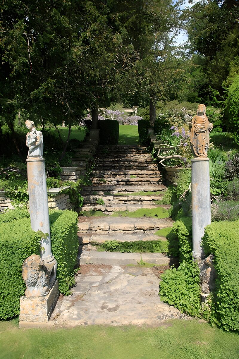 Märchenhafter Gartenweg mit Statuen