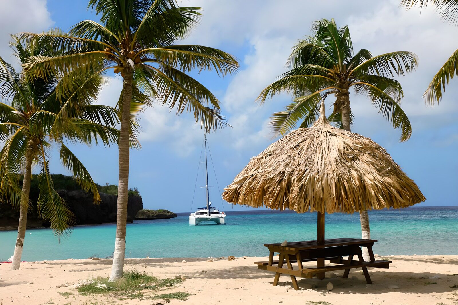 Traumstrand mit Palmen und Segelboot