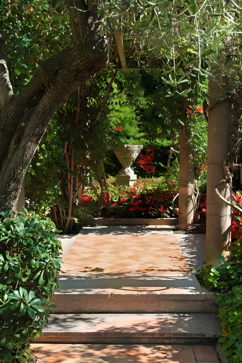 Blühender Gartenweg mit Skulptur