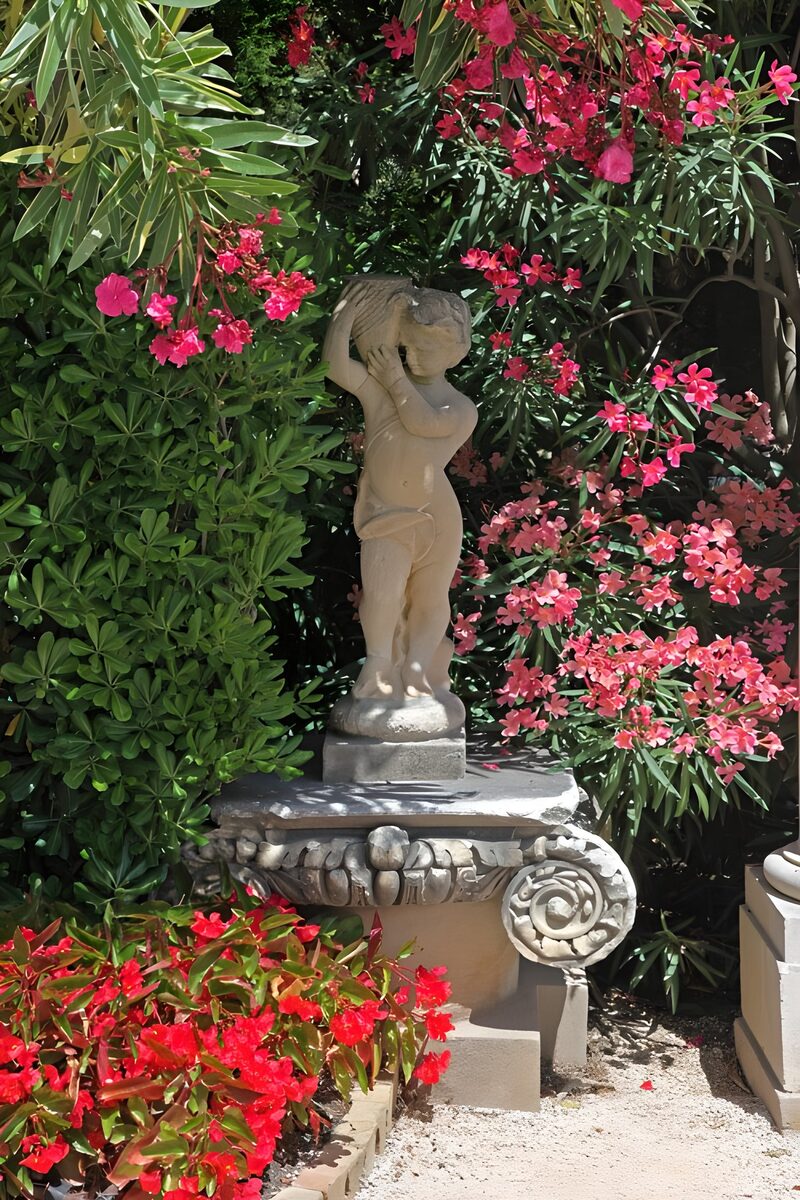 Statue im Garten mit bunten Blumen