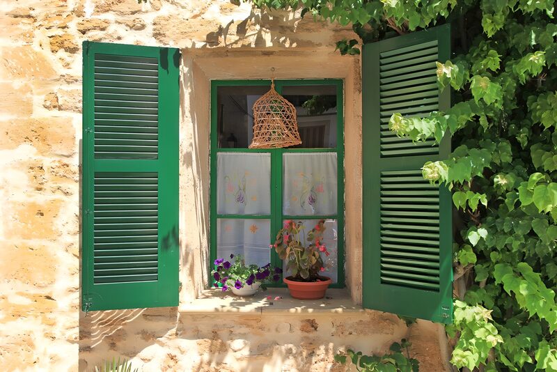 Charmantes Fenster mit grünen Shutters
