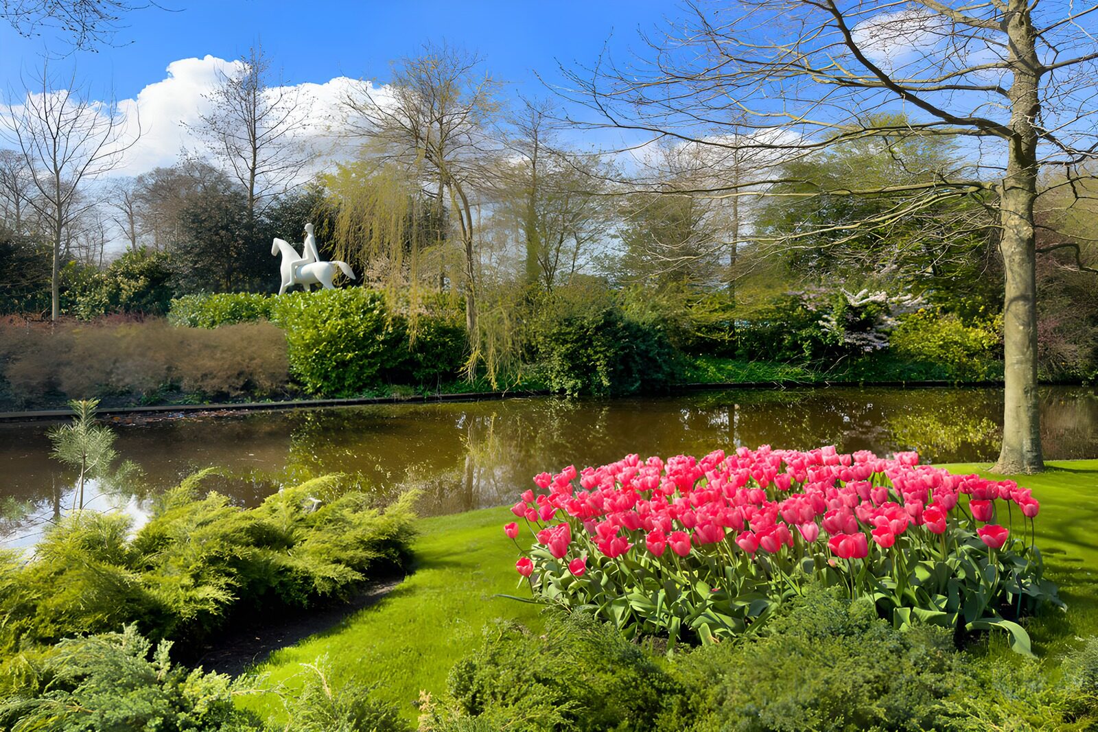 Frühlingsgarten mit Statue und Tulpen