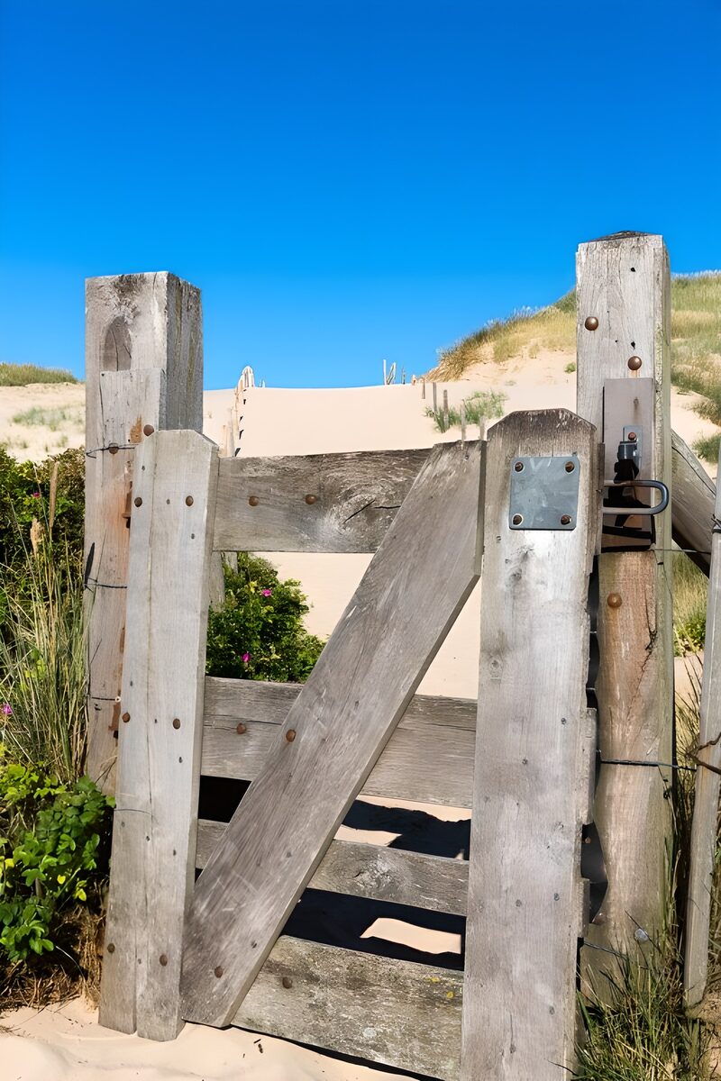 Holztor zum Strand bei sonnigem Wetter