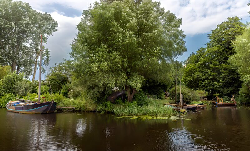 Friedlicher Fluss mit Booten und Bäumen